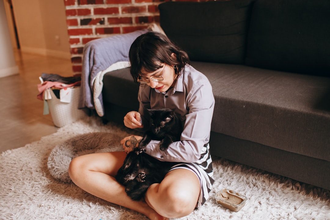 猫とくつろぎながら本を読む女性